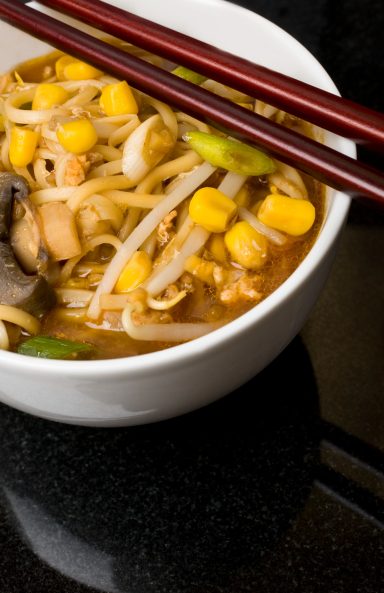 Chicken and sweetcorn soup in a bowl with chopsticks