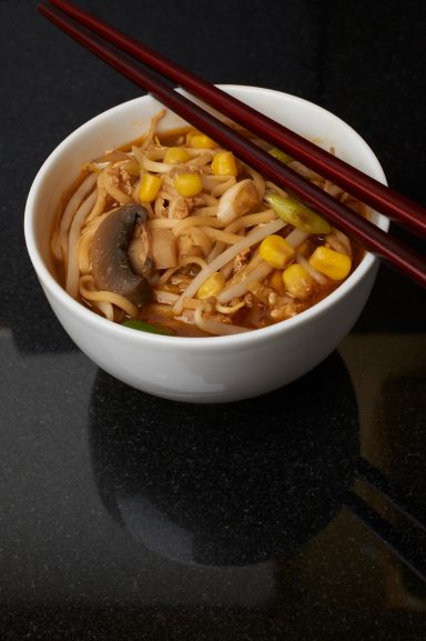 Chicken and sweetcorn soup in a bowl with chopsticks