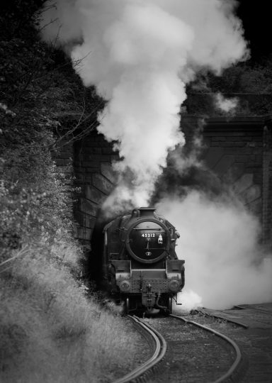 Black Five steam train leaving the tunnel
